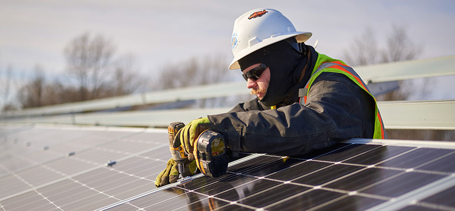 Consumers Energy worker maintaining solar panels at Blackman Solar Garden site